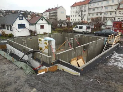 Grunnmuren ferdig, gjenfylling rundt murer delvis gjort. Nesten klart tilflytting av Huset tilbake